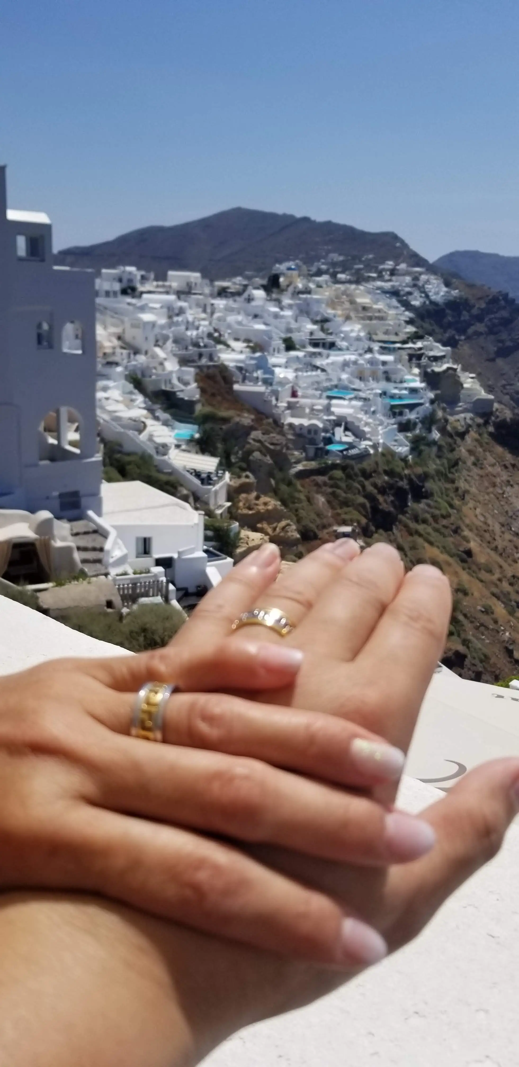 Darren and Chrystina's hands wearing their rings during their Santorini vow renewal.